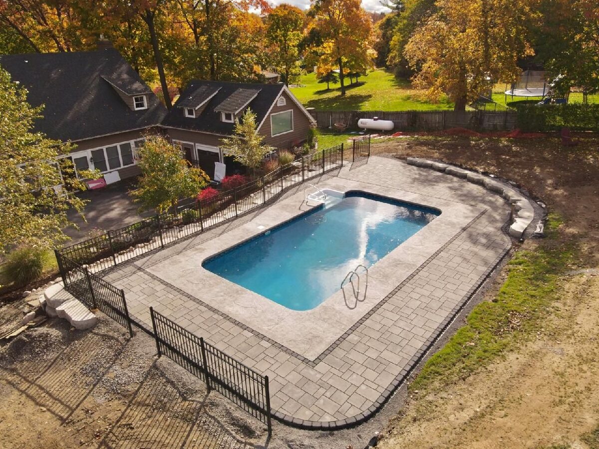 Completed stamped concrete pool deck surrounding an in-ground pool in Central New York