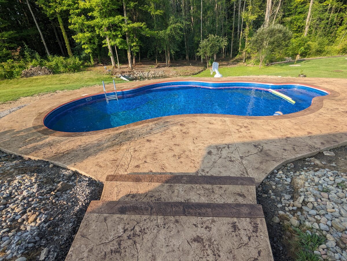Stamped concrete pool deck with custom steps in Central New York