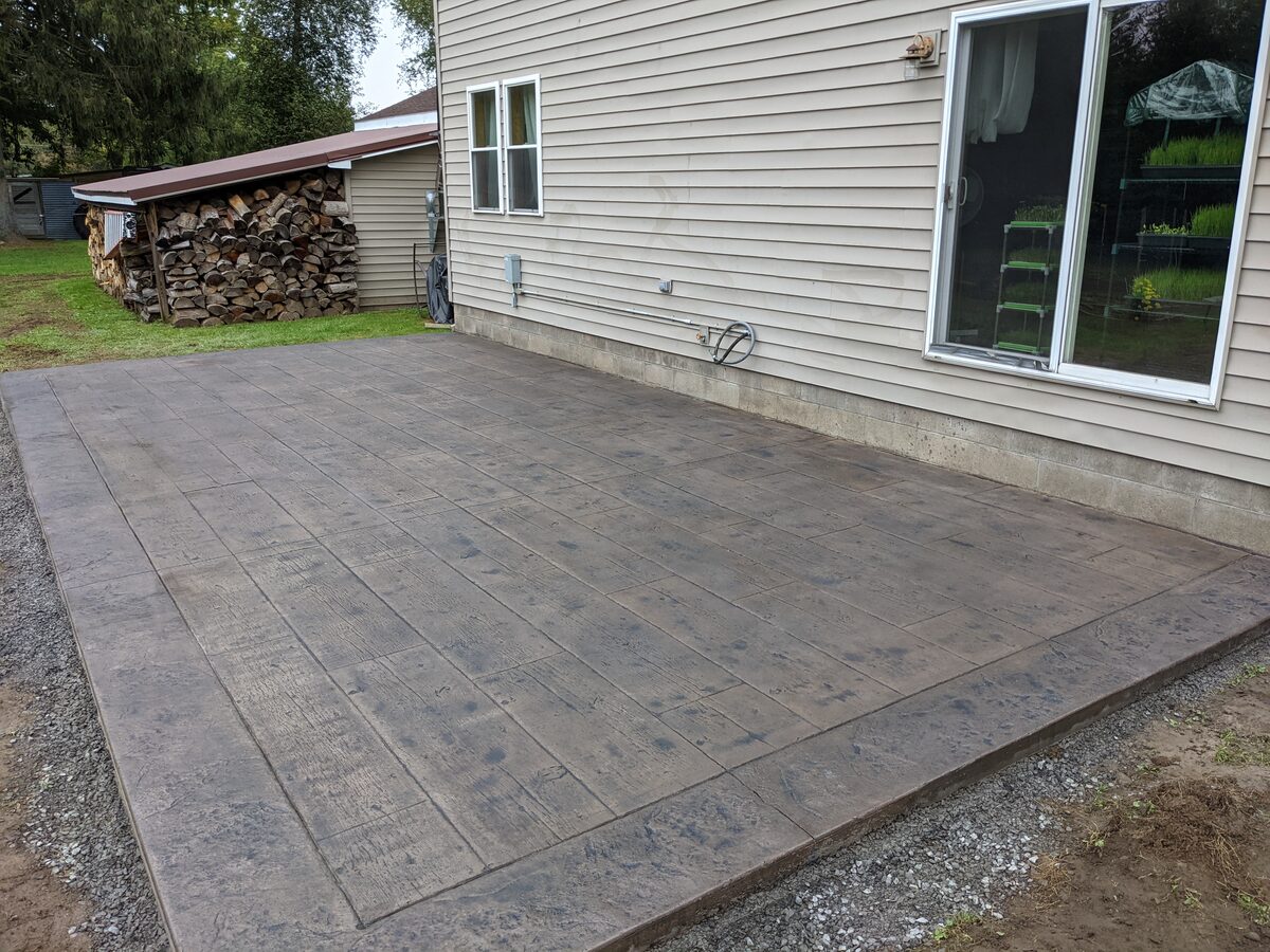 Wood plank stamped concrete patio behind a Syracuse NY home